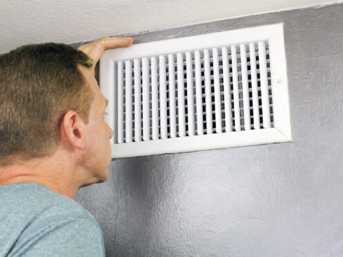 A man checking an AC vent in Playa Vista