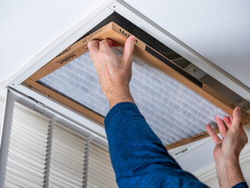 A man changing the air filter of the AC system.